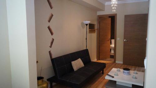 巴塞罗那格斯亚大道舒适之家酒店的客厅配有黑色沙发和桌子