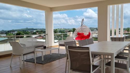 BonouaVilla Bolati, avec piscine, jacuzzi, jardin et vue的阳台的用餐室配有桌椅