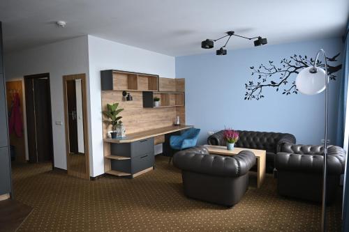 莱格尼察ApartHotel Legnica - apartamenty z aneksem kuchennym的客厅配有两张真皮座椅和书桌