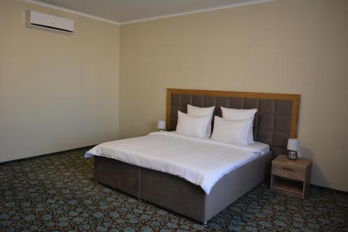 阿克托比Гостиничный комплекс "Коктобе"的一间卧室配有带白色床单和枕头的床。