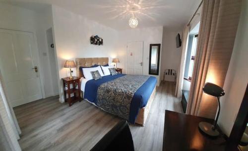 马拉费尔特Moyola River Cottage的一间卧室配有蓝色床和蓝色棉被