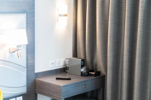 凡尔赛凡尔赛大厦酒店的酒店客房配有带电视和窗帘的书桌