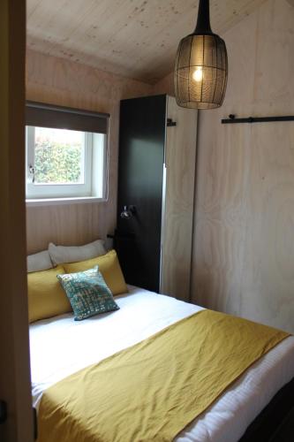 LiempdeHalte Liempde Logies的一间卧室配有一张带黄色毯子和窗户的床