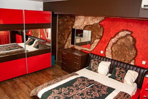 卢科维特Vilhelmov’s apartament的一间卧室设有两张床和红色的墙壁