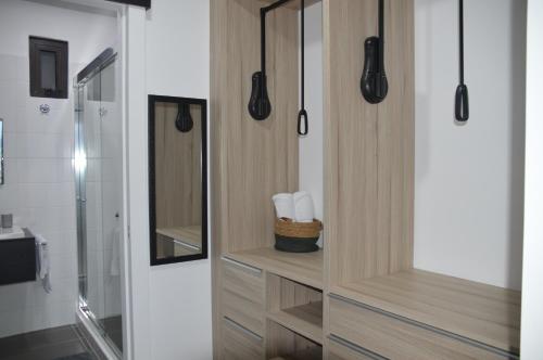 危地马拉Cozy Stays Cayala Apartments 7的带淋浴的浴室以及带毛巾的木制橱柜。