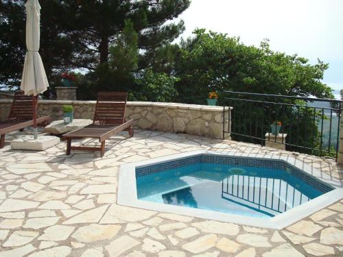 KariáMerlot Village Rental Apartments的一个带桌椅的庭院内的游泳池
