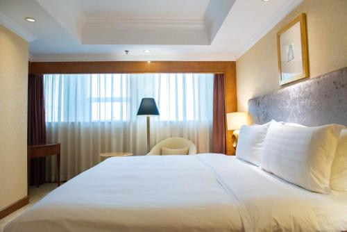 青岛青岛颐中皇冠假日酒店的一间设有大床和窗户的酒店客房