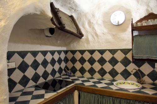 韦斯卡尔Cuevas La Atalaya的浴室设有可检查的柜台和墙上的时钟