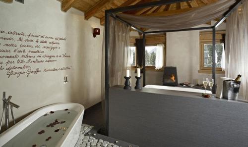 摩德纳迪-坎皮格里奥多尔齐维塔小木屋精品酒店的带浴缸和浴缸的浴室。