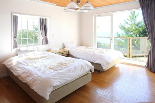 土庄町YURURI private cottage的带2扇窗户的客房内的2张床