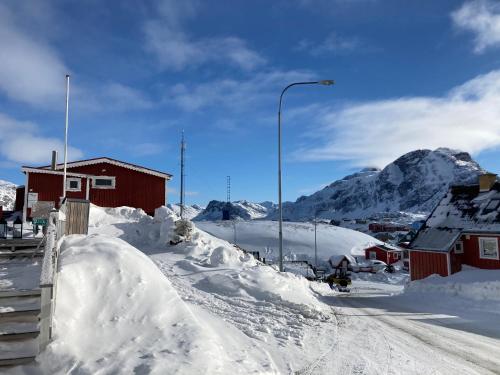 西西缪特Isi4u apartments, snowmobile and dogsled的一条雪覆盖的街道,背景是山