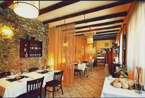卡瓦内斯VÍA NATURA hotel rural gastronómico的一间带桌椅和石墙的餐厅