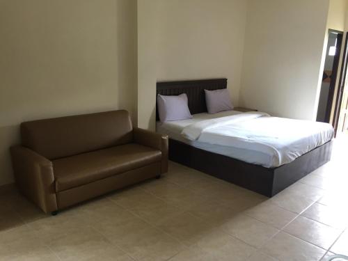 芭堤雅市中心phuriburi resort的一间卧室配有一张床和一把椅子