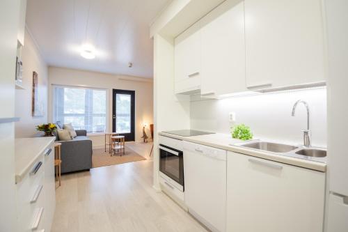 卡拉约基Apartment Hilmantori kaksio saunalla Kalajoki的一间带白色橱柜的厨房和一间客厅