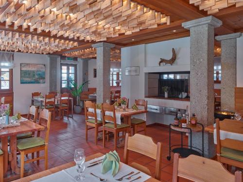 雷金根Hotel Glocke的餐厅铺有木地板,配有桌椅