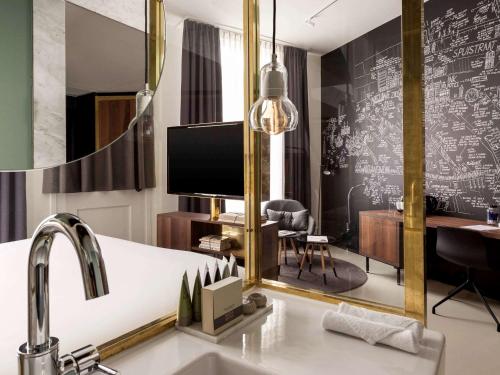 阿姆斯特丹INK Hotel Amsterdam - MGallery Collection的一间带水槽和镜子的浴室
