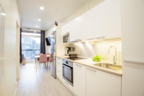 卡拉约基Apartment Aurinkoranta D7 saunallinen kaksio Kalajoki的厨房配有白色橱柜和水槽