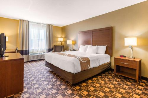 乔治城Quality Inn & Suites Georgetown - Seaford的酒店客房设有一张大床和一台电视。