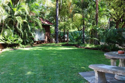 LephalaleDe la Rose Guesthouse的草地上带两张野餐桌的院子