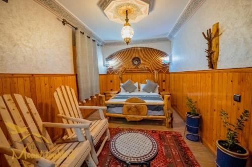 伊姆利尔Mount Toubkal Lodge的一间卧室配有一张床和两张木椅