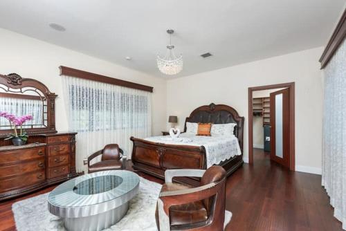 迈阿密Villa Toscana - Luxury with Pool的一间卧室配有一张床和一张玻璃桌