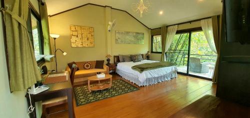 Ban Muang SoiUTOPAI Stone Garden Vacation Home, Pai!的一间卧室配有一张床和一张沙发