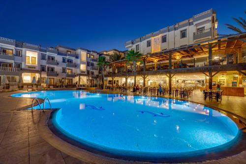 居姆贝特Smart Holiday Hotel & Suite Bodrum- All Inclusive的夜间在度假村的一个大型游泳池