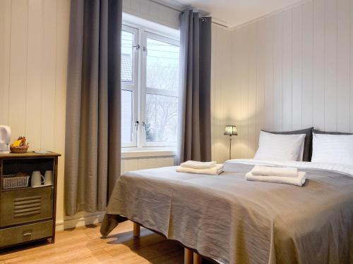 巴特斯峡湾Båtsfjord Brygge - Arctic Resort的一间卧室配有一张大床和两条毛巾