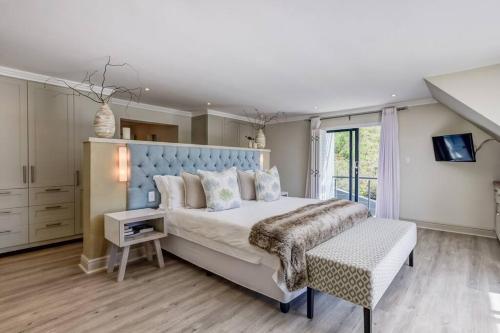 克尼斯纳Forest Edge Golf and Sea Villa的一间卧室配有一张大床和蓝色床头板