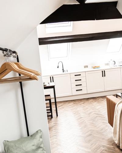 阿什顿下安林恩Urban Loft Apartment • 1 Bedroom • Manchester的厨房配有白色橱柜和黑色天花板