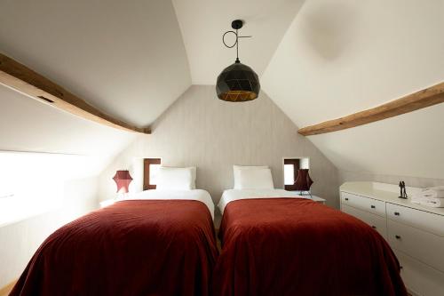 奥德纳尔德Enjoytoday 49 - Luxueus familieverblijf aan de voet van de Koppenberg的阁楼卧室配有两张带红色毯子的床