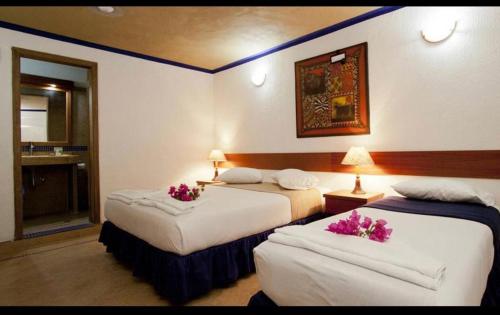 El YaqueHotel Posada La Mar的两张位于酒店客房的床,上面有鲜花