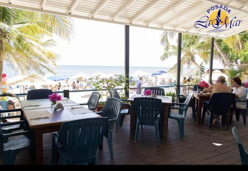 El YaqueHotel Posada La Mar的一间带桌椅的餐厅,享有海滩美景