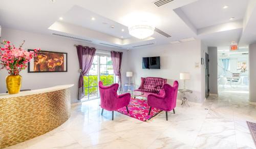 迈阿密海滩Secret Garden Miami Beach的客厅配有粉红色的椅子和桌子