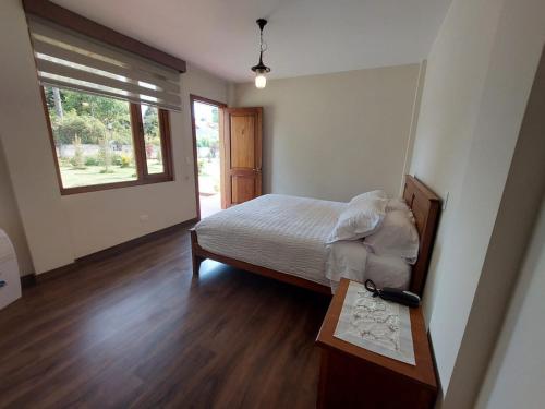塔巴贝拉Quinta San Felipe的一间卧室配有一张床、一张桌子和一个窗户。