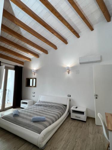 普拉L’ANGELO BIANCO的一间带一张大床的卧室,位于一个拥有木制天花板的房间