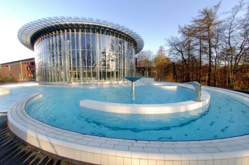 斯帕Van der Valk Hotel Spa的大楼前的大型游泳池