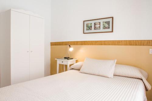 福恩吉罗拉诺玛丽耶旅舍的卧室配有白色的床和台灯。