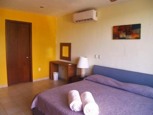 科苏梅尔Beachfront Apartment Your Home in Cozumel的一间卧室配有一张带两条白色毛巾的床