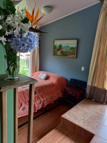 San IsidroSuite y Loft Casa Toría的一间卧室,配有一张床,桌子上放着花瓶