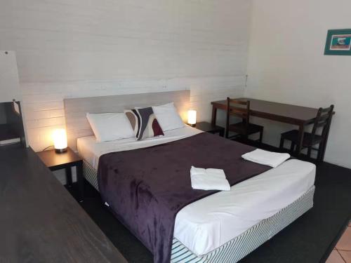 麦凯天堂汽车旅馆的一间卧室配有一张带两张桌子的床和一张书桌