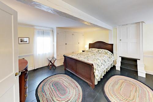 WiscassetNickels-Sortwell House的一间卧室配有一张床和两块地毯