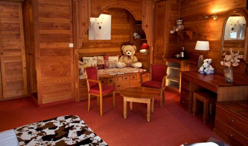 莱德萨阿尔卑斯Hôtel Serre Palas的一间房间,配有一张桌子和泰迪熊