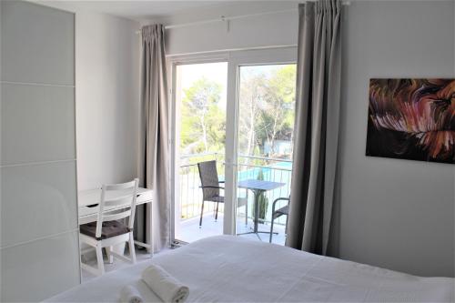 米欧纳Villa Lovisa, private pool and amazing sea view的一间卧室配有一张床铺和一张桌子,并设有一个阳台