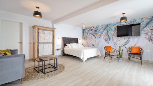 PájaraEtti - Paradise Suite El Olivo y el Mar的一间卧室配有一张床,墙上配有电视