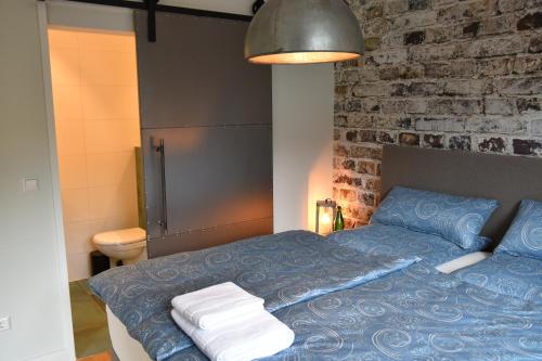 HinterweidenthalAnnettes Pfalz的一间卧室设有蓝色的床和砖墙