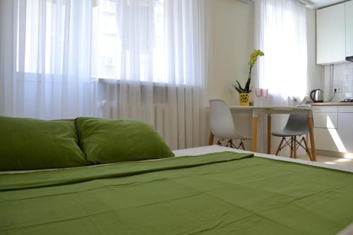 克列缅丘格Honey Bunny的一间卧室配有一张绿色的床和一张桌子