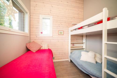 索特Lomamökki, loistava sijainti的一间小卧室,配有双层床和红色地毯
