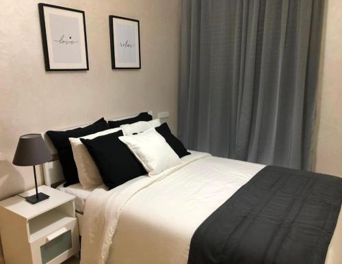 诺阿瑟Good appartement near at the aeroport的一间卧室配有一张带黑白枕头的床
