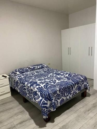马查拉Suite de lujo totalmente independiente的卧室配有蓝色和白色的床和橱柜。